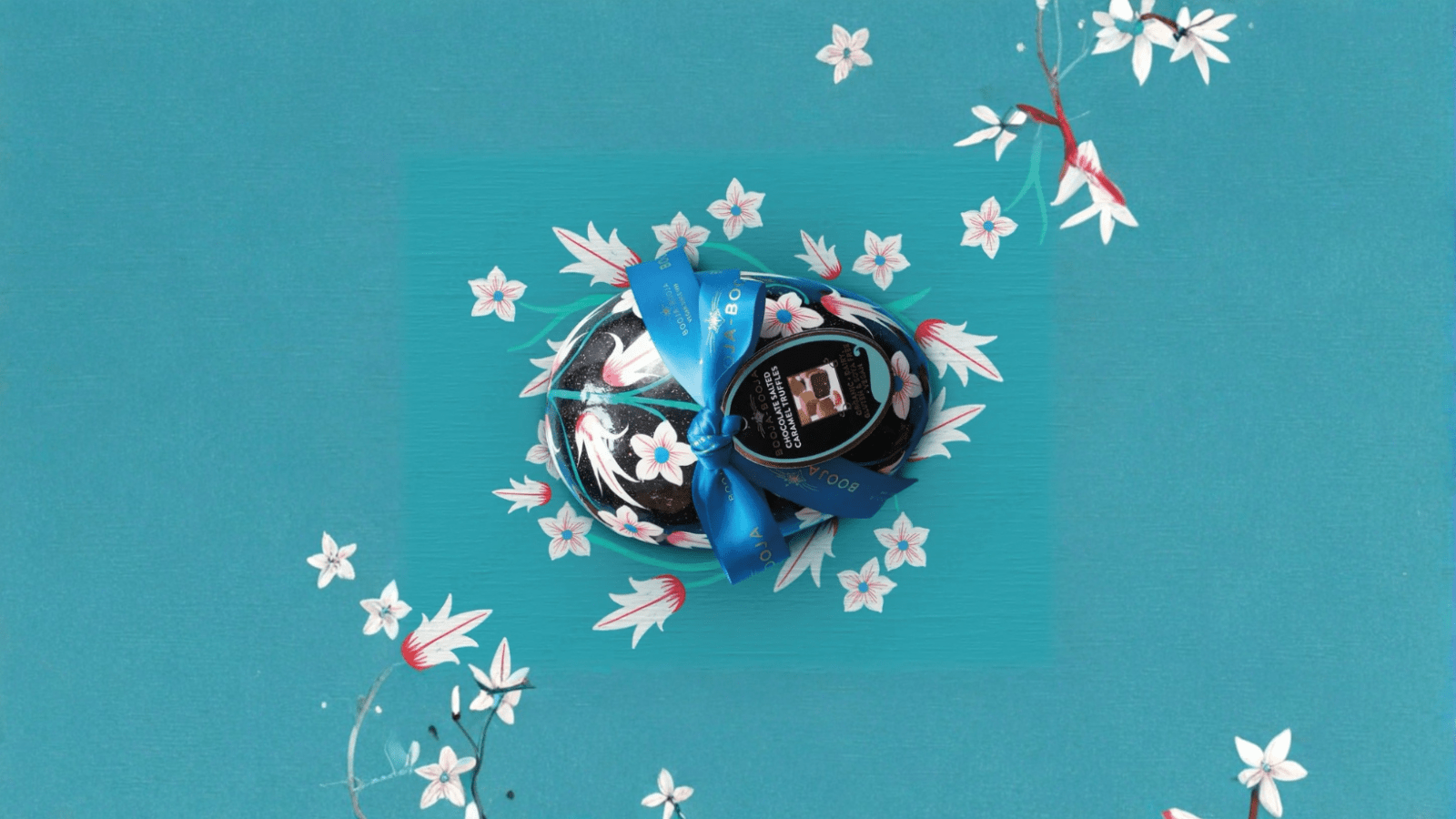 Booja-Booja Easter egg on blue background with white flowers